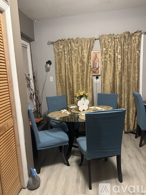 A dining room with a table set for four.