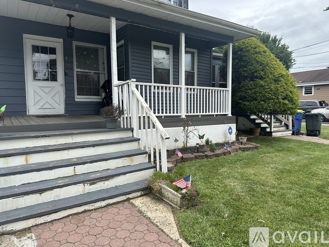 A house with a blue exterior and a white porch.