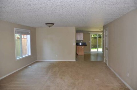 Empty room with a window and a door leading to another room.