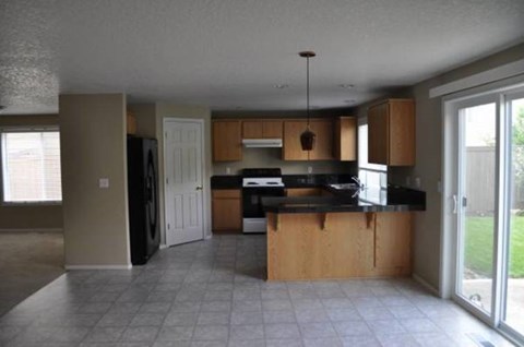 A kitchen with a black counter top and wooden cabinets.