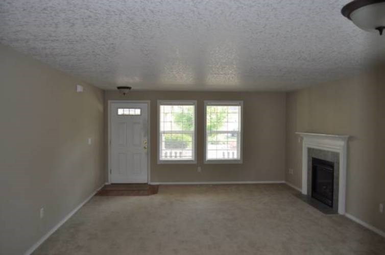 A room with a fireplace and two windows.
