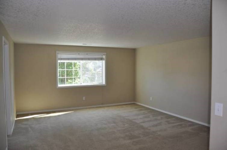 A room with a window and carpeted floor.