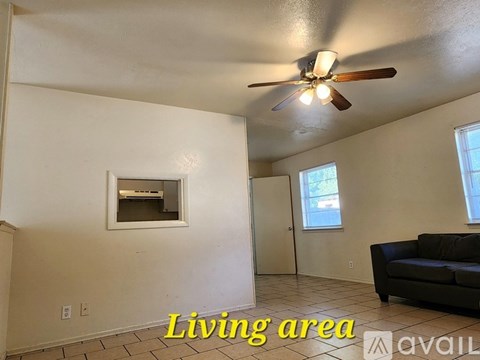 A living area with a couch and a ceiling fan.