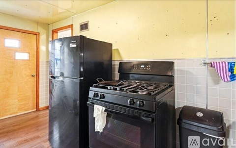 A black stove and refrigerator in a kitchen.