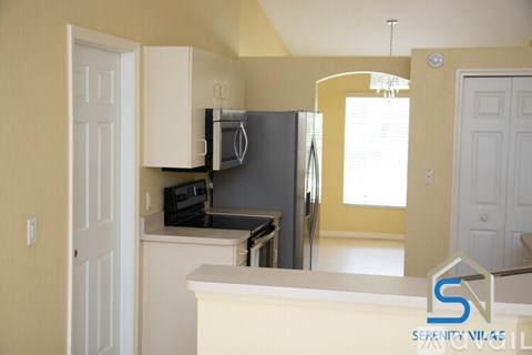 A kitchen with a white counter and a microwave above the stove.