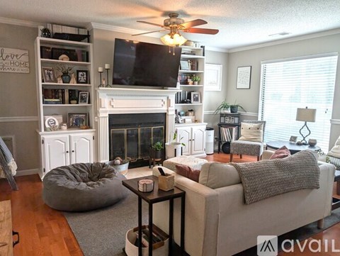 A living room with a fireplace and a television on the wall.