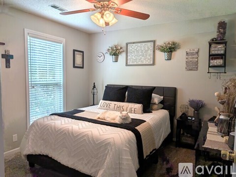 A bedroom with a large bed and a ceiling fan.