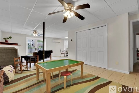A room with a pool table and a ceiling fan.