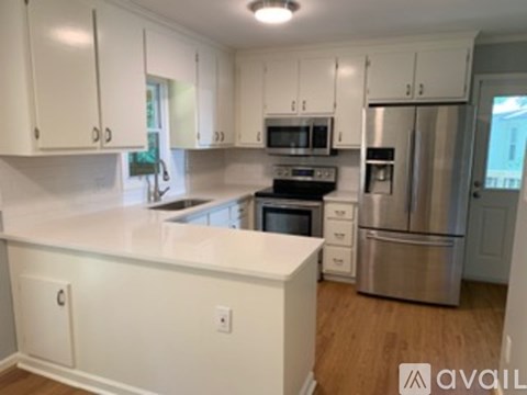 A kitchen with white cabinets and a white counter top.