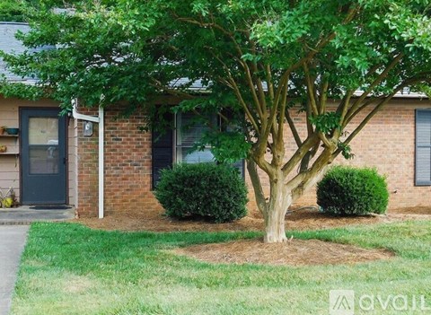 A brick house with a green lawn in front.