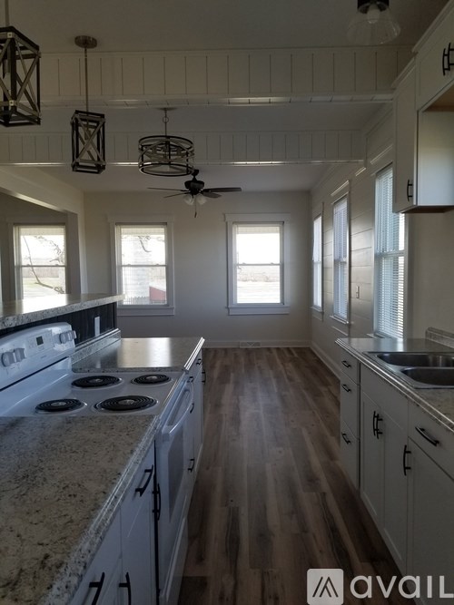 A kitchen with wooden floors and white cabinets.