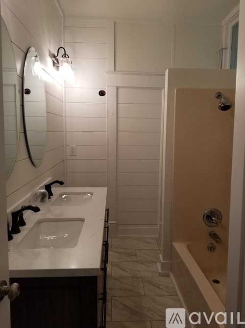 A bathroom with a sink, mirror, and shower.