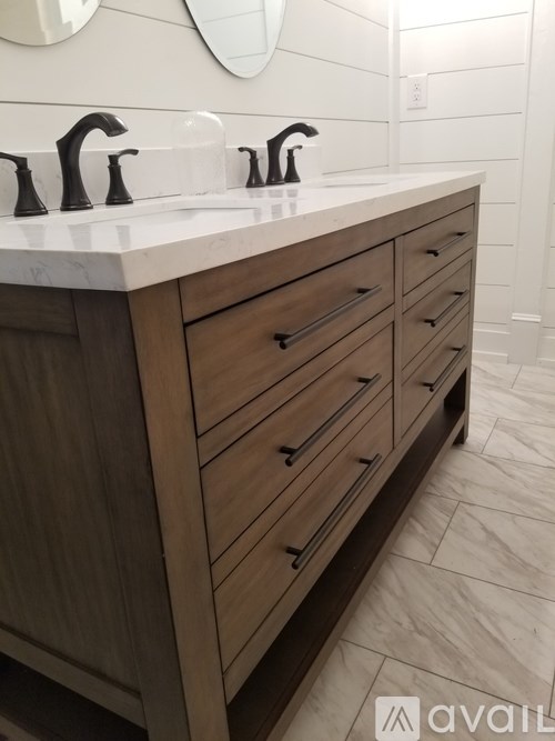 A bathroom vanity with a white countertop and wooden drawers.