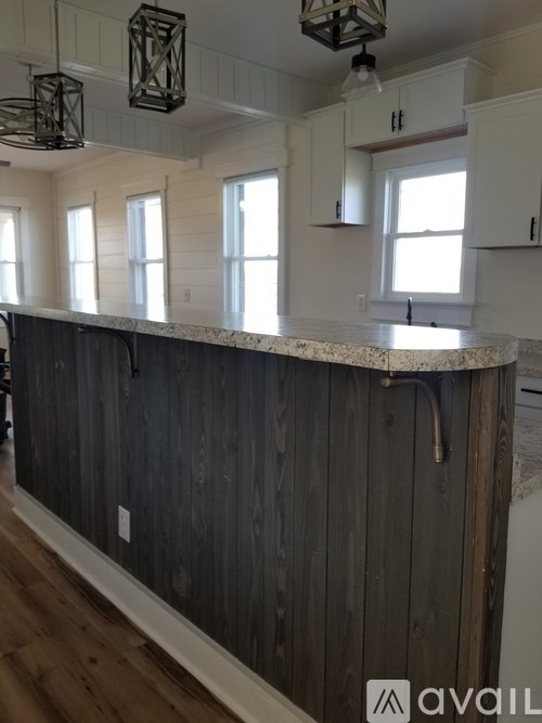 A kitchen with a dark wood counter and white cabinets.