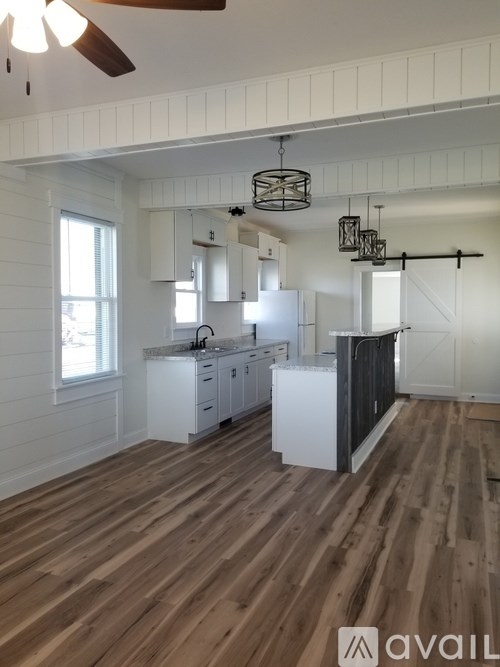 A kitchen with wooden floors and white walls.