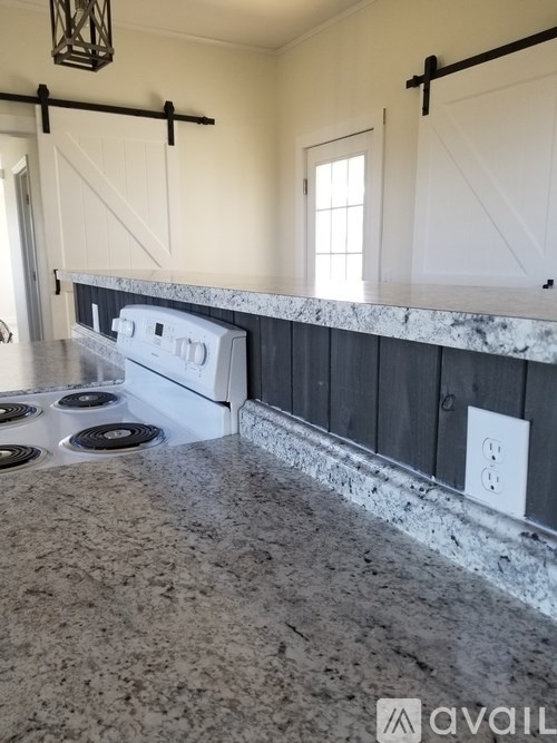 A kitchen counter with a white oven and a window.