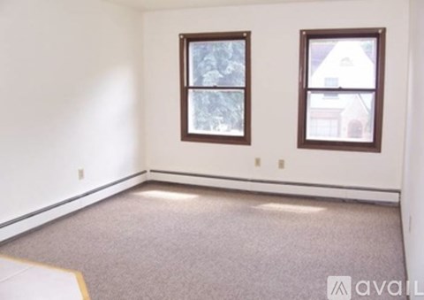 A room with two windows and carpeted floor.