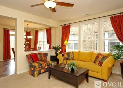 A living room with a yellow couch and a coffee table.