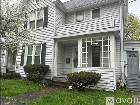 A two-story house with a front porch and a small front yard.