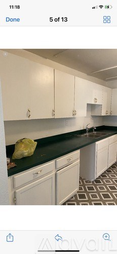 A kitchen with white cabinets and a green bag on the counter.