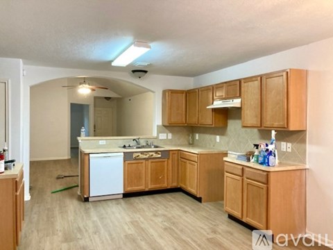 A kitchen with wooden cabinets and a white dishwasher.