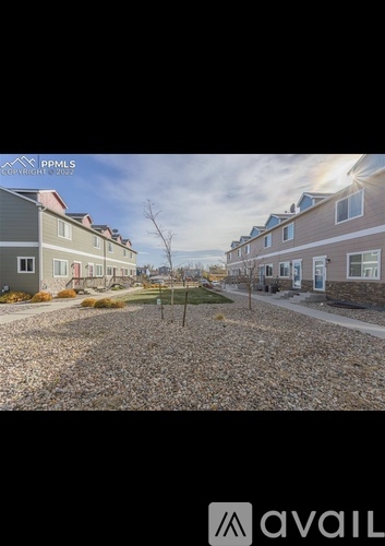 A gravel lot in front of a row of houses.
