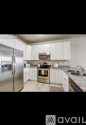A kitchen with white cabinets and stainless steel appliances.