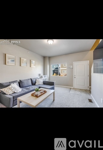 A living room with a grey couch and a coffee table.