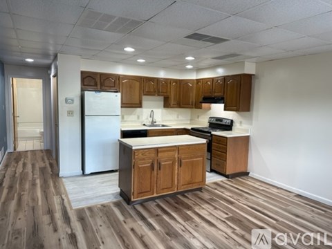 A kitchen with wooden cabinets and a white refrigerator.