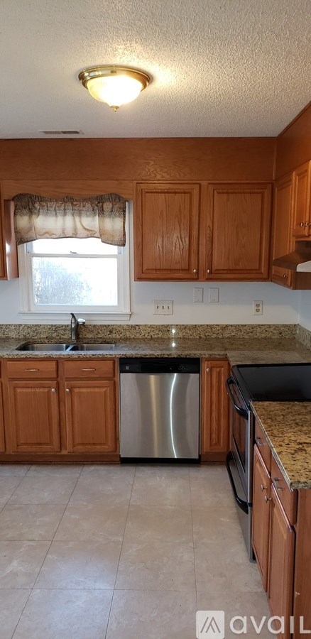 A kitchen with wooden cabinets and a granite countertop.