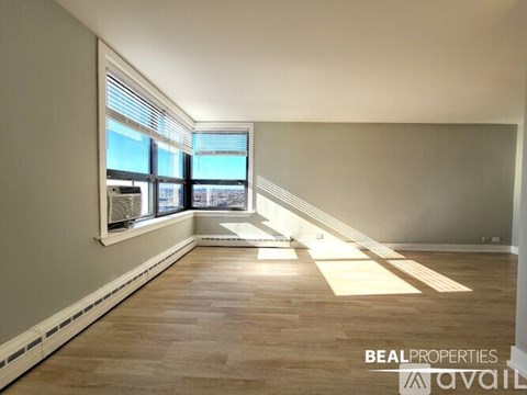 A room with wooden flooring and a ceiling fan with a light.