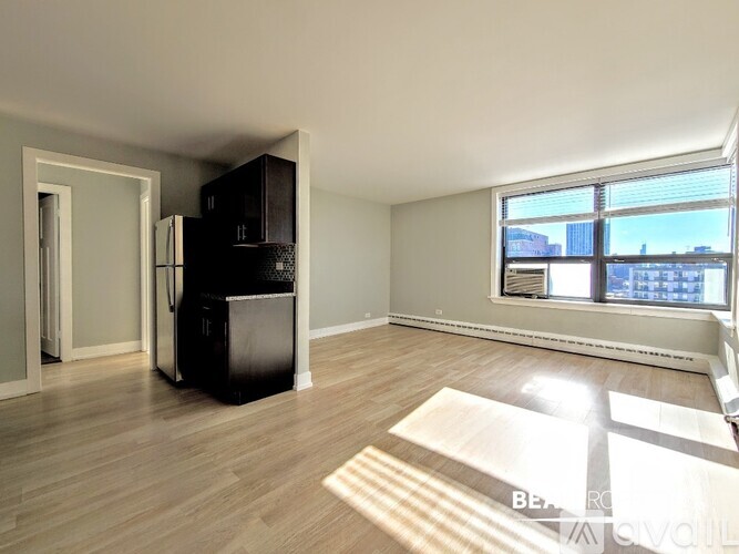 A kitchen with wooden floors and a countertop with a refrigerator, microwave, and oven.