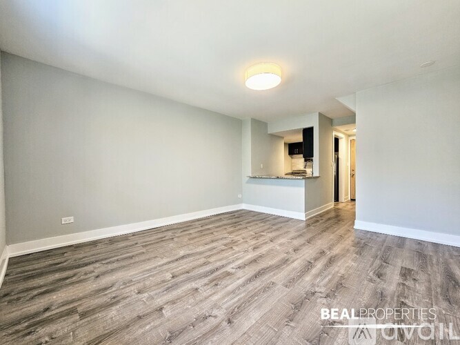 A long hallway with wood flooring and white walls.