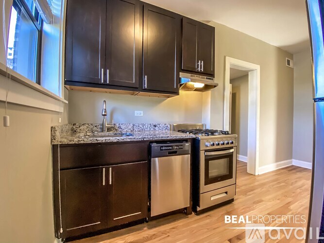 A kitchen with black cabinets and stainless steel appliances.