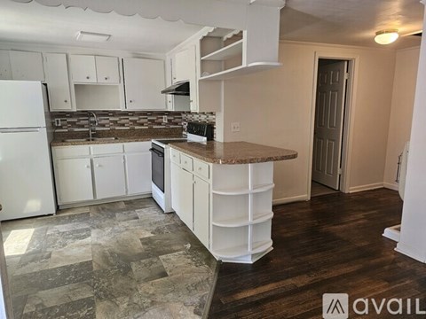 A kitchen with white cabinets and a marble countertop.
