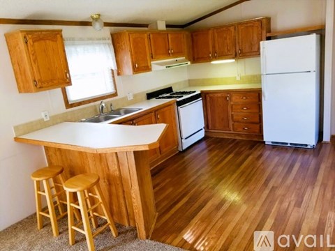 A kitchen with wooden cabinets and a white fridge.