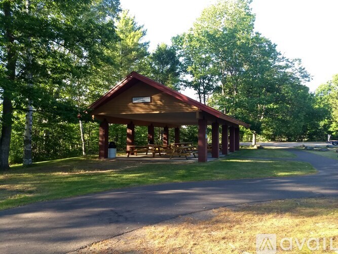 A pavilion in a park with trees surrounding it.