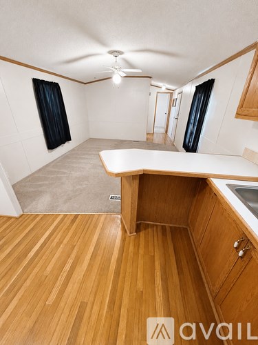 A hallway with a wooden floor and white walls.