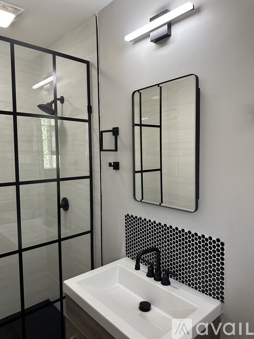 A modern bathroom with a white sink and a mirror above it.