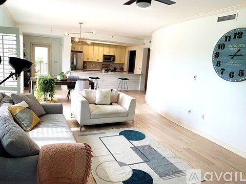 A living room with a grey couch and a white chair.