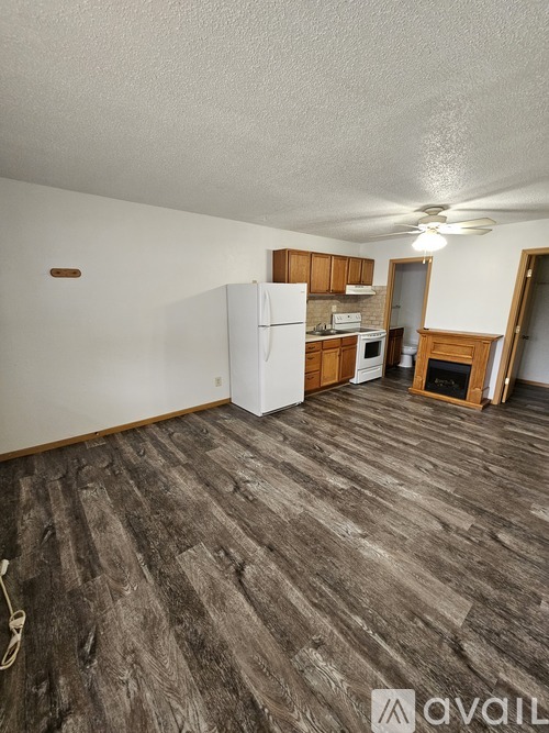 A kitchen area with a white refrigerator and wooden cabinets.