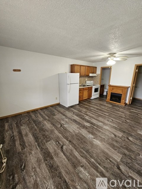 A kitchen area with a white refrigerator and wooden cabinets.