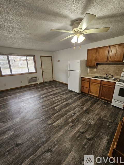 A kitchen with wooden floors and white appliances.