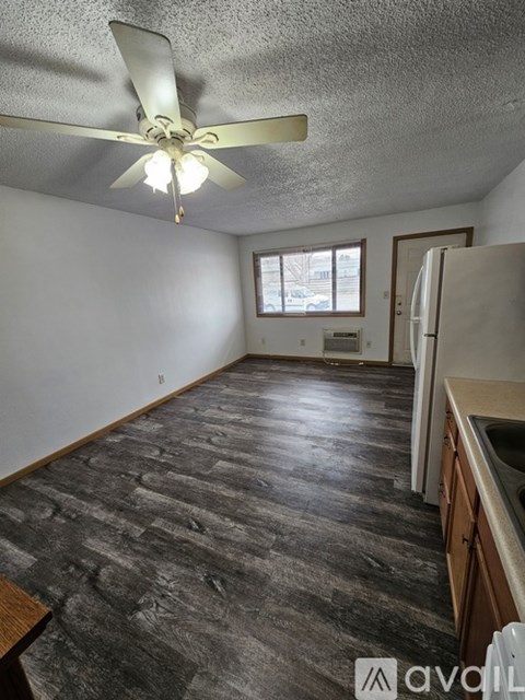 A room with a ceiling fan and a window.