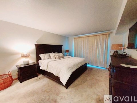 A bedroom with a large bed and a wooden dresser.