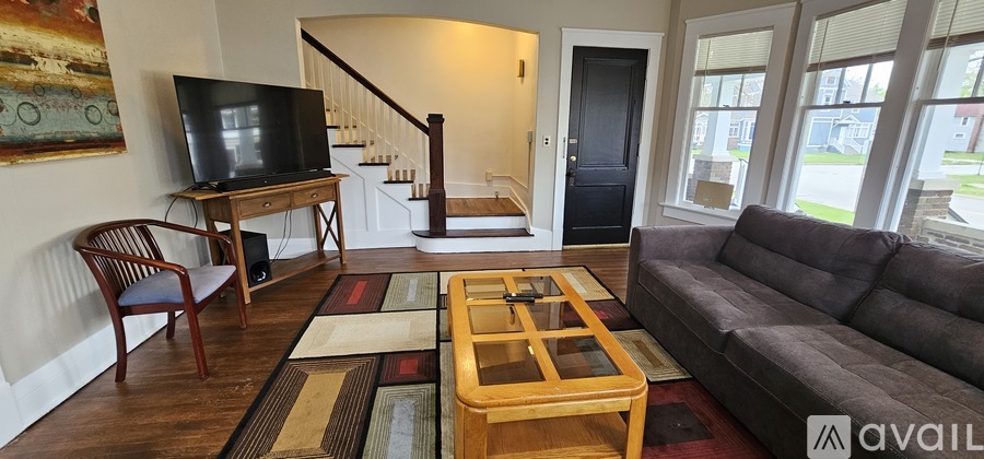 A living room with a couch, chair, and television.