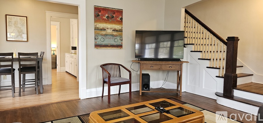 A living room with a television and a staircase.