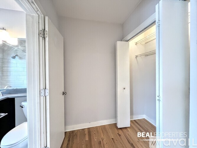 A room with a white door and a wooden floor.