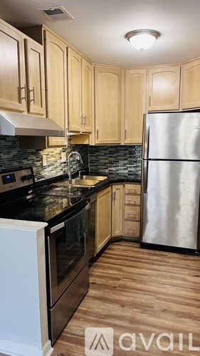 A kitchen with wooden cabinets and a black countertop.
