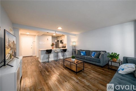 A living room with a grey couch and a wooden floor.